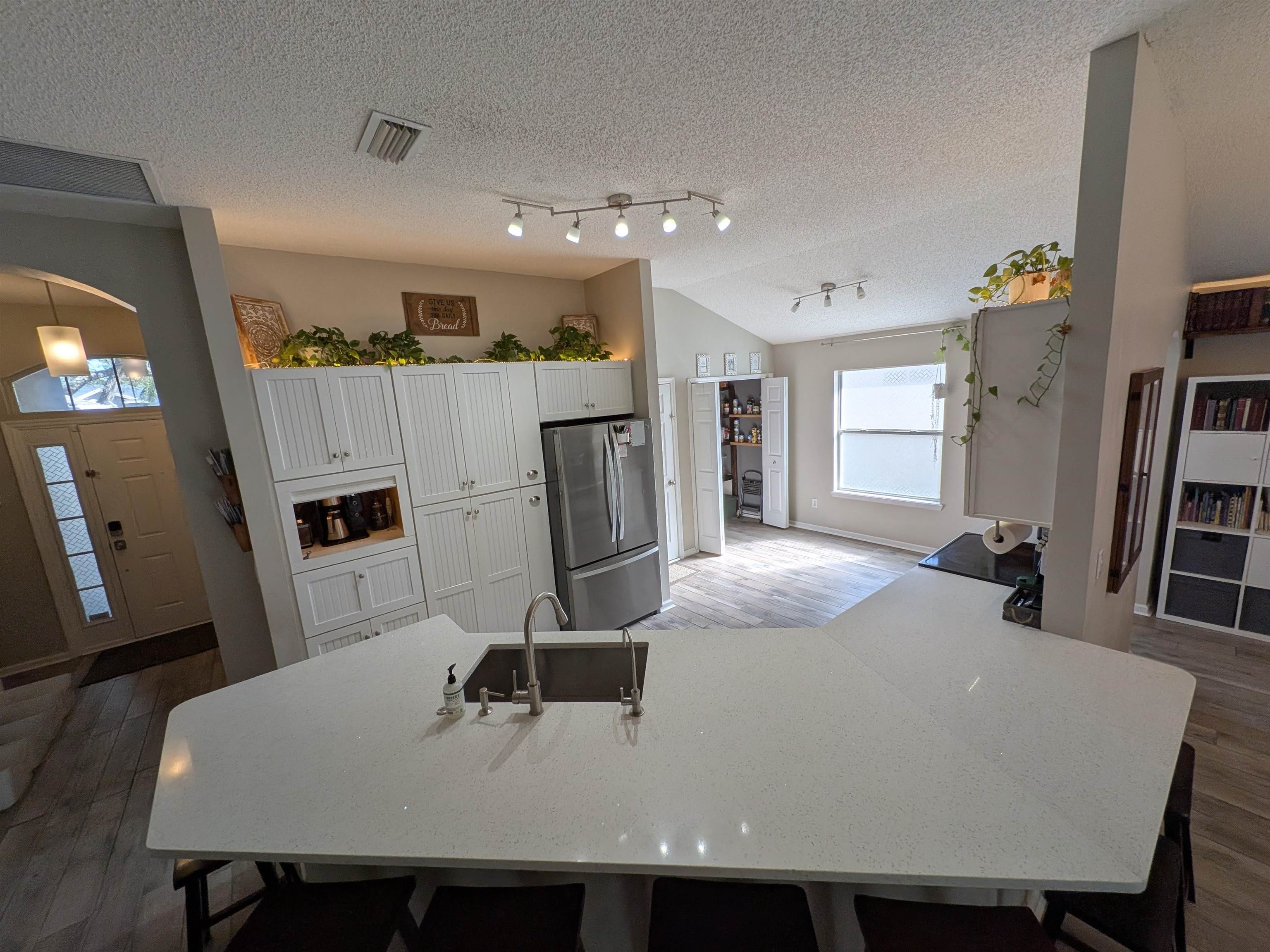 921 Oak Arbor Circle St. Augustine, FL 32084 - Photo 15 of 51 a dining room with kitchen island furniture a sink a refrigerator and a flat screen tv