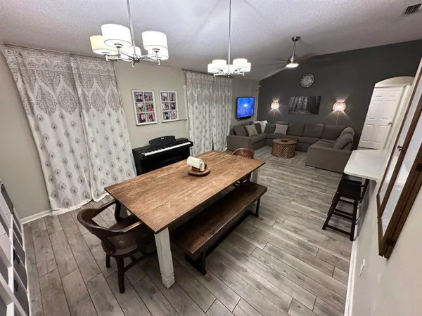 a view of a dining room with furniture and a chandelier