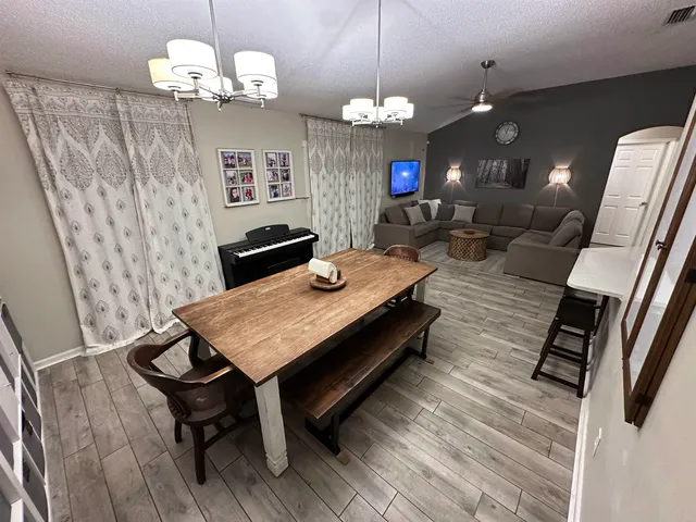a view of a dining room with furniture and a chandelier