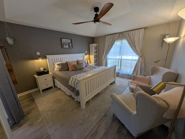 a bedroom with a bed a couch and a ceiling fan