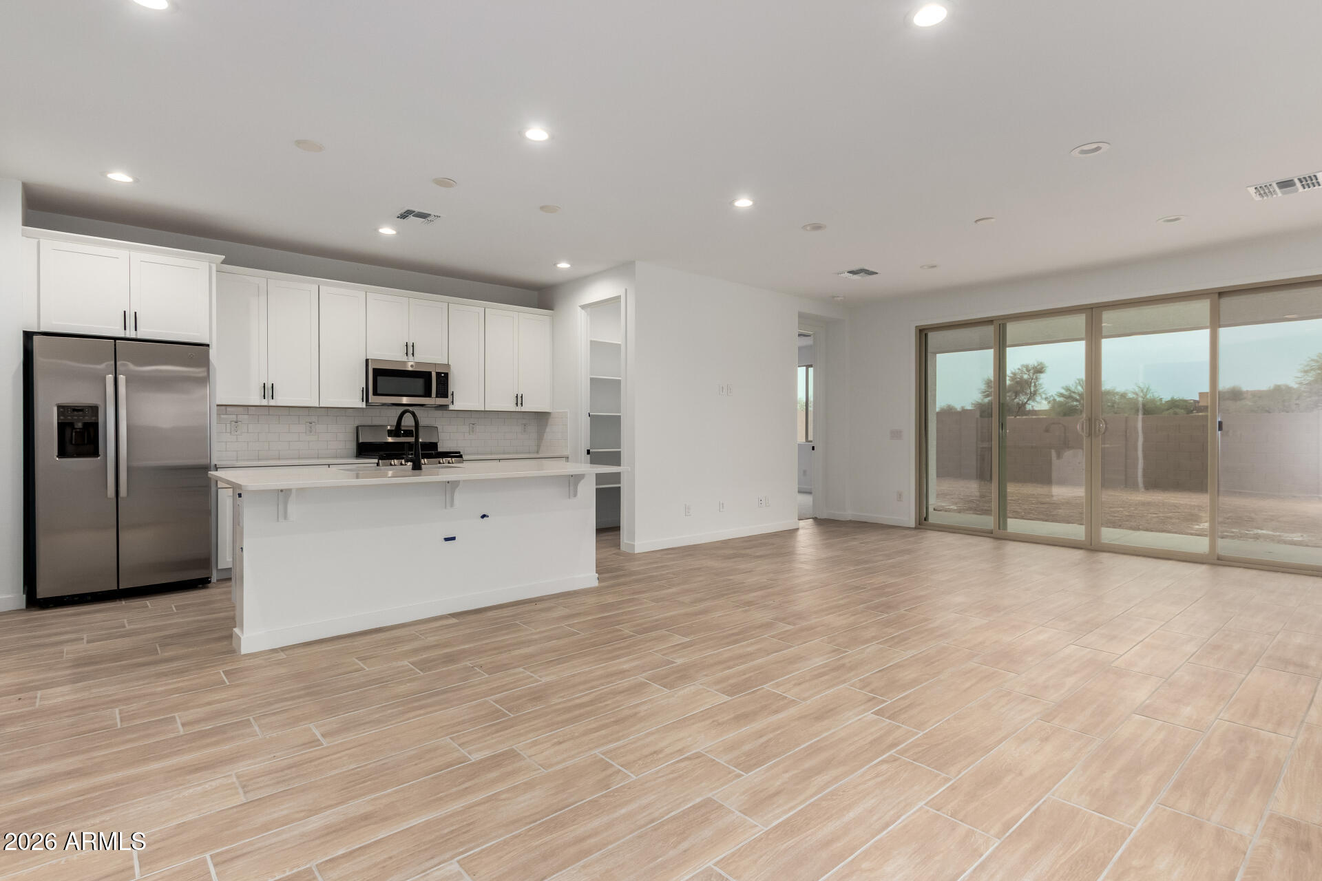 8026 West Granada Road Phoenix, AZ 85035 - Photo 5 of 31 a large kitchen with stainless steel appliances a large counter top and a refrigerator
