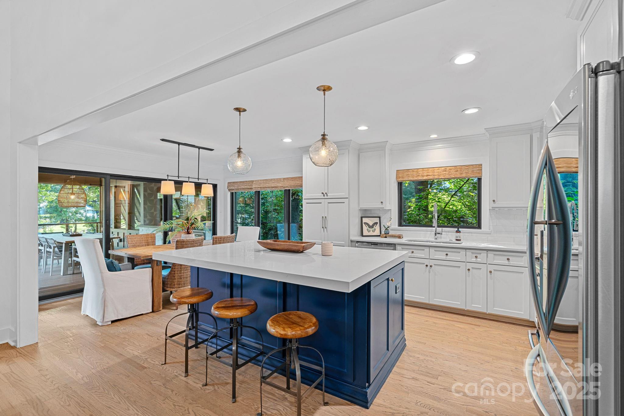 19624 Meta Road Cornelius, NC 28031 - Photo 9 of 44 a open kitchen with stainless steel appliances granite countertop a stove a refrigerator a kitchen island a table and chairs