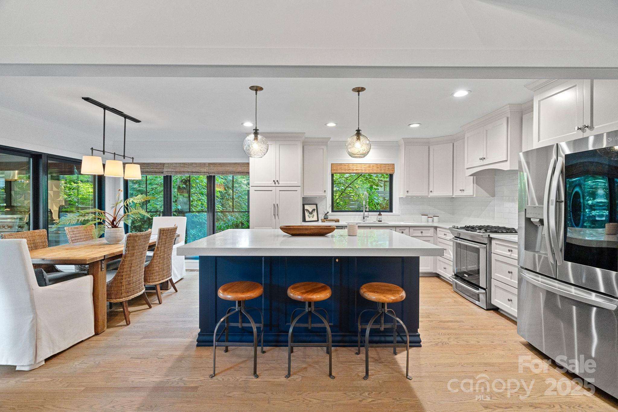 19624 Meta Road Cornelius, NC 28031 - Photo 10 of 44 a kitchen with stainless steel appliances granite countertop a table chairs sink and wooden cabinets