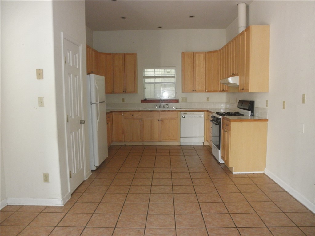 109 West 38th Street, Unit A Austin, TX 78705 - Photo 3 of 16 a kitchen with a sink a stove top oven and cabinets