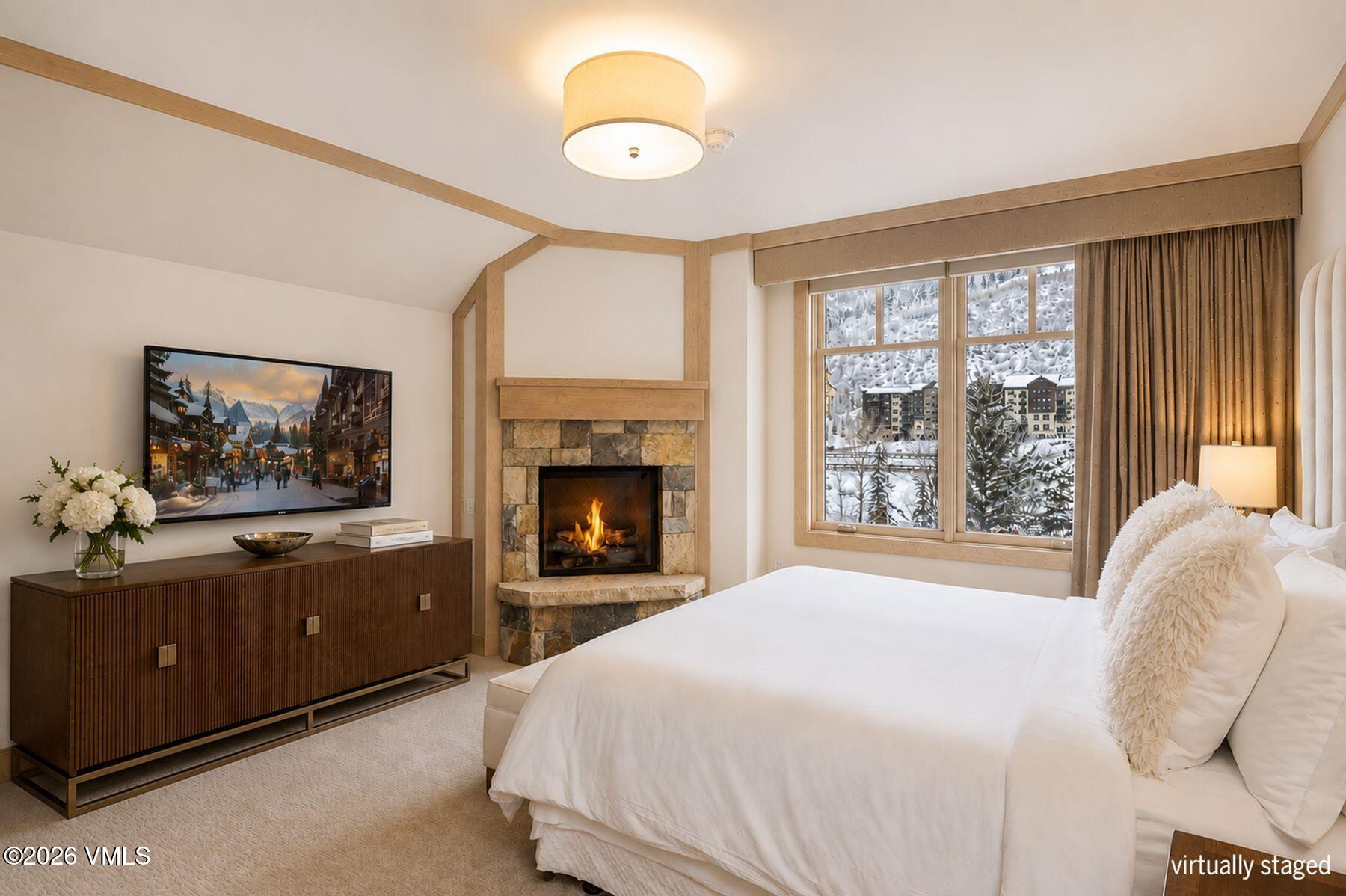 1 Vail Road, Unit 9204 Vail, CO 81657 - Photo 13 of 27 a spacious bedroom with a bed and a fireplace