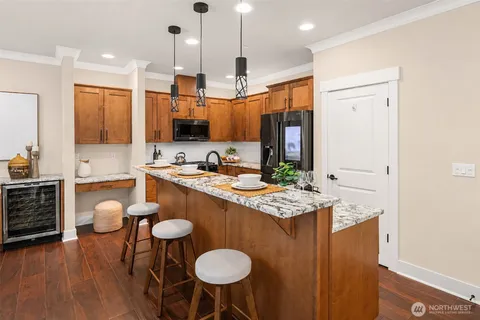 a kitchen with stainless steel appliances granite countertop a sink a stove and a wooden floors