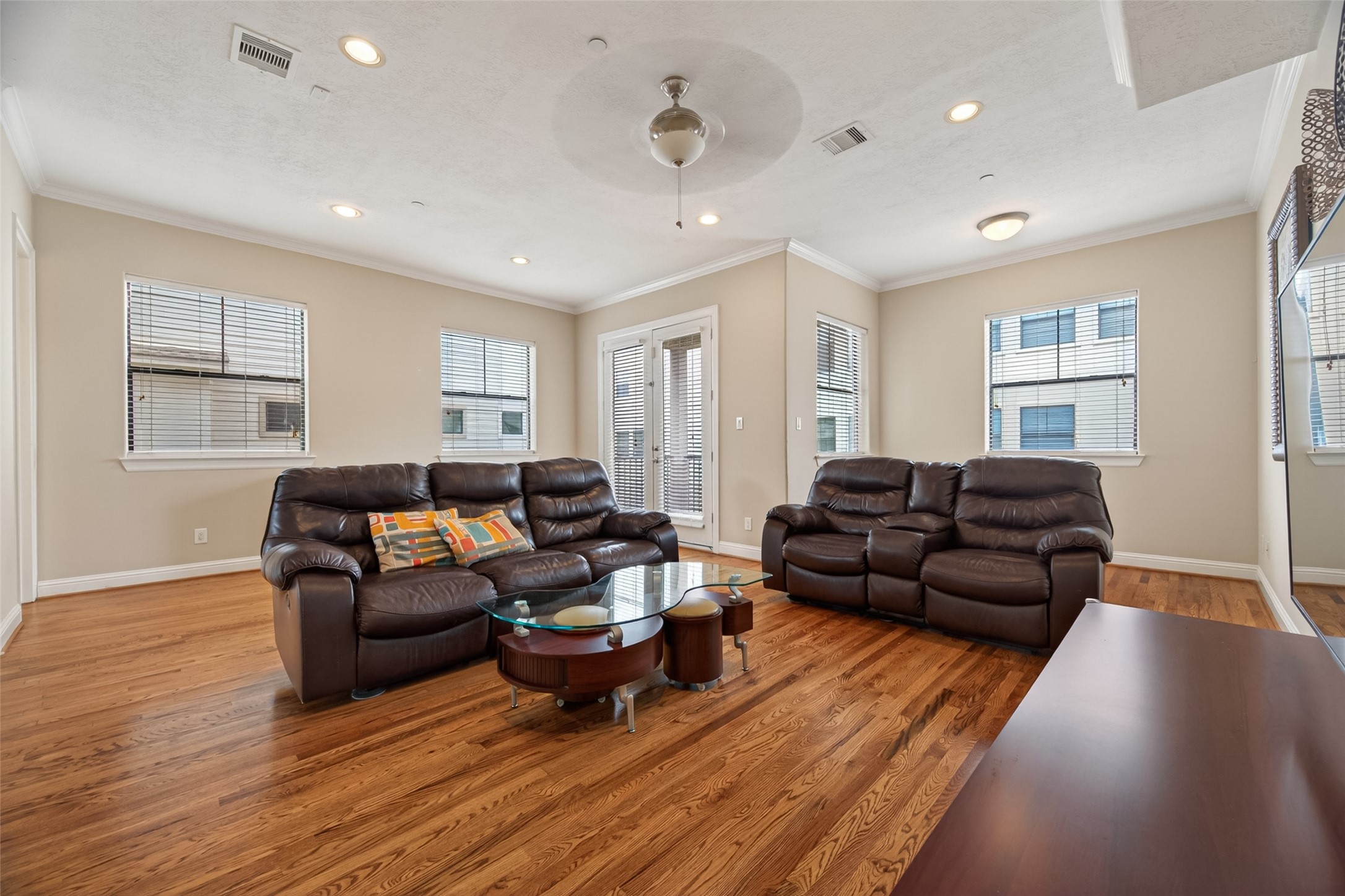 2611 Riverside Drive, Unit C Houston, TX 77004 - Photo 8 of 50 This spacious living room features rich hardwood floors, neutral tones, and abundant natural light streaming through multiple windows. With direct access to the second-floor balcony and a seamless connection to the beautifully appointed kitchen, the space is ideal for both everyday living and entertaining. It offers a warm, inviting atmosphere with plenty of room to relax and gather.