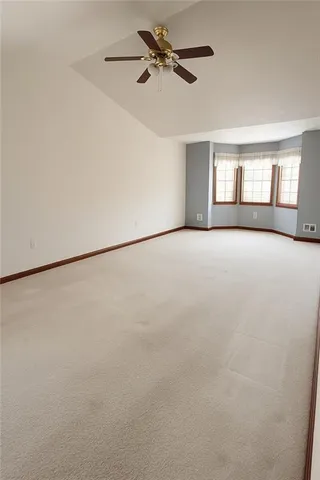 an empty room with closet and a ceiling fan