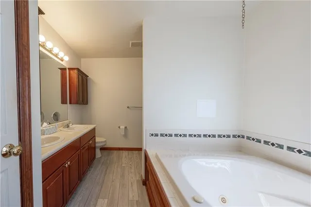 a bathroom with a tub sink and mirror