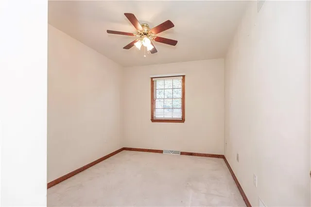 an empty room with a empty space and a ceiling fan