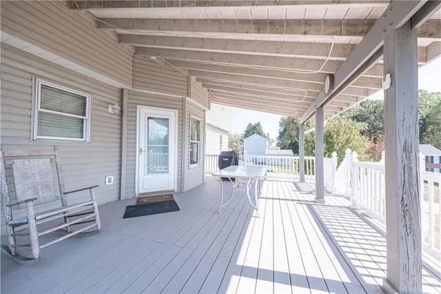 a view of a house with wooden deck and furniture