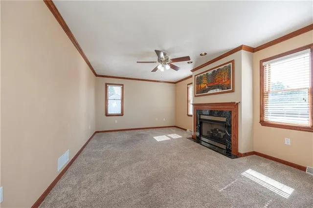 an empty room with windows and fireplace