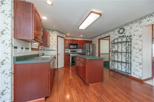 a kitchen with stainless steel appliances granite countertop a stove cabinets and wooden floor