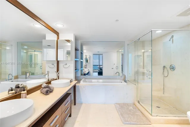 a bathroom with a tub sink shower and mirror