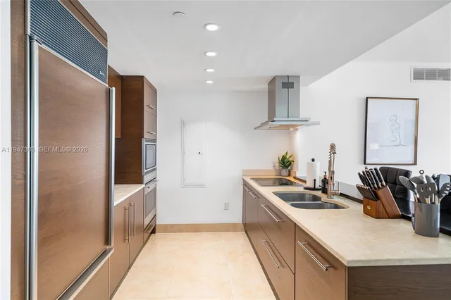 a kitchen that has a sink stainless steel appliances and cabinets
