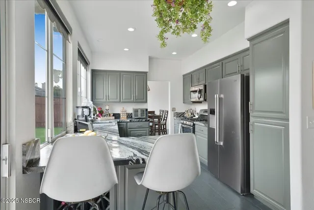 a view of a dining room with furniture a kitchen and chandelier