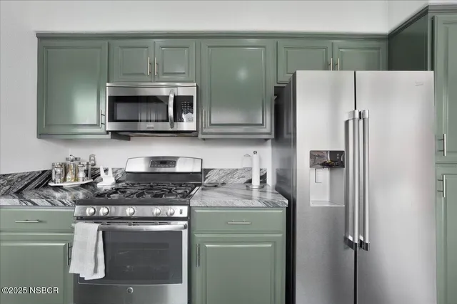 a kitchen with stainless steel appliances granite countertop a refrigerator sink and microwave
