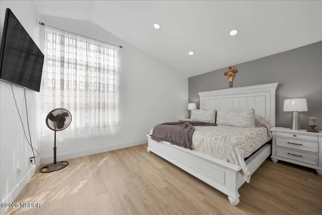 a spacious bedroom with a bed and a flat screen tv