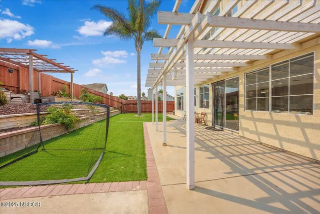 a view of a house with backyard and sitting area