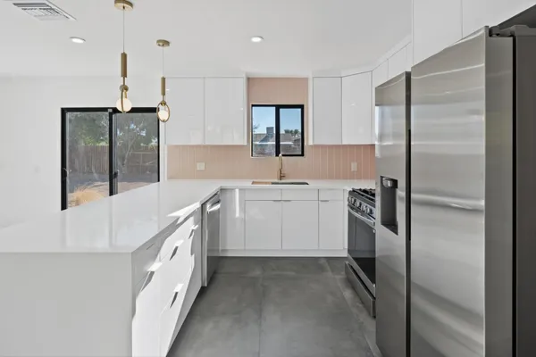 a kitchen with white cabinets and stainless steel appliances