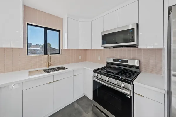 a kitchen with cabinets stainless steel appliances and a sink