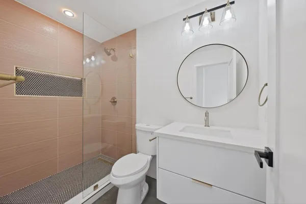 a bathroom with a toilet sink a shower and a mirror