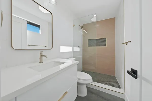 a bathroom with a sink a toilet and shower