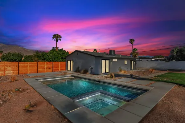 a view of a house with swimming pool and a yard