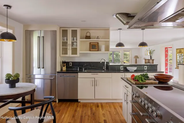 a kitchen with stainless steel appliances granite countertop a stove and white cabinets