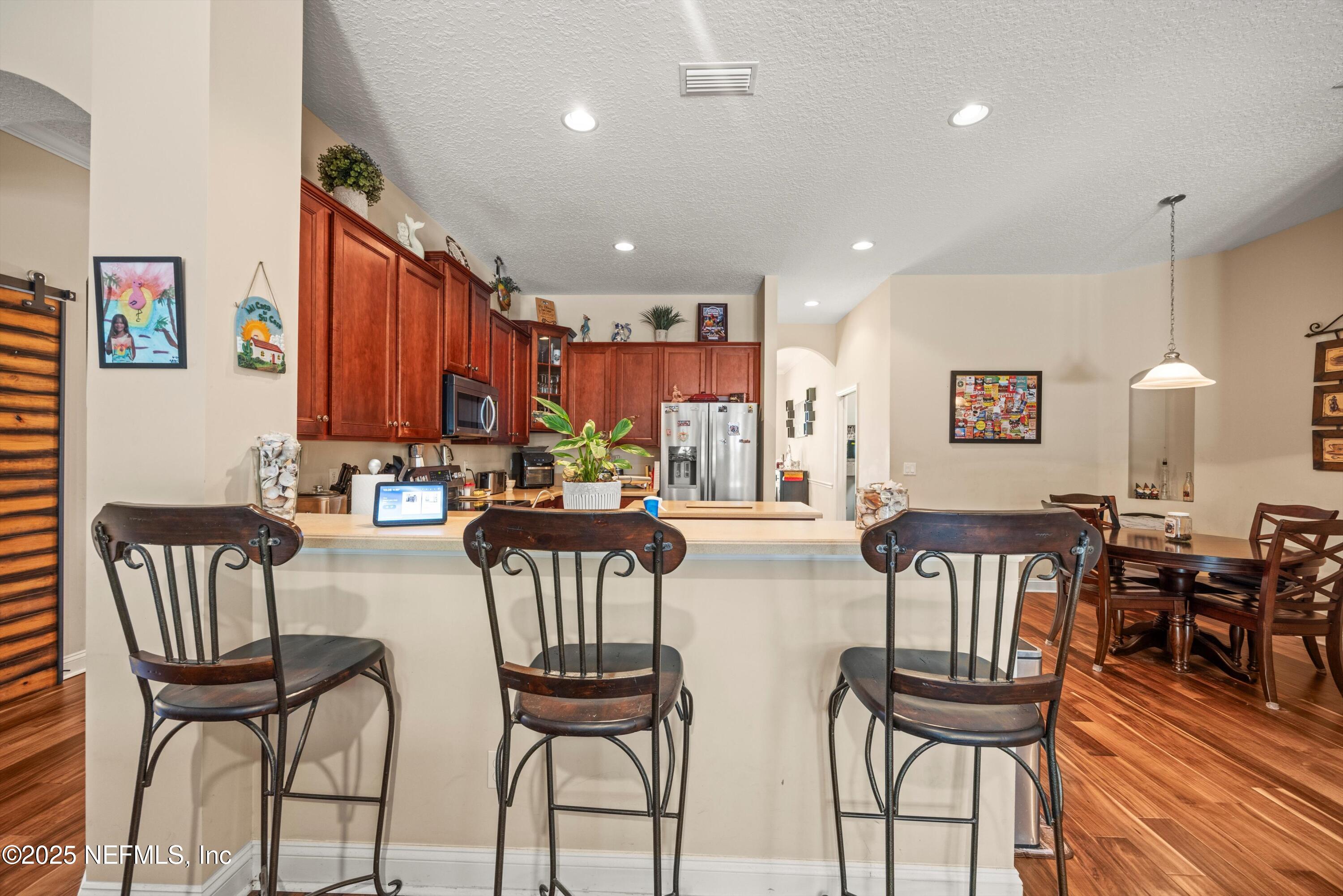 648 Battersea Drive St. Augustine, FL 32095 - Photo 22 of 59 a view of a dining room with furniture and wooden floor