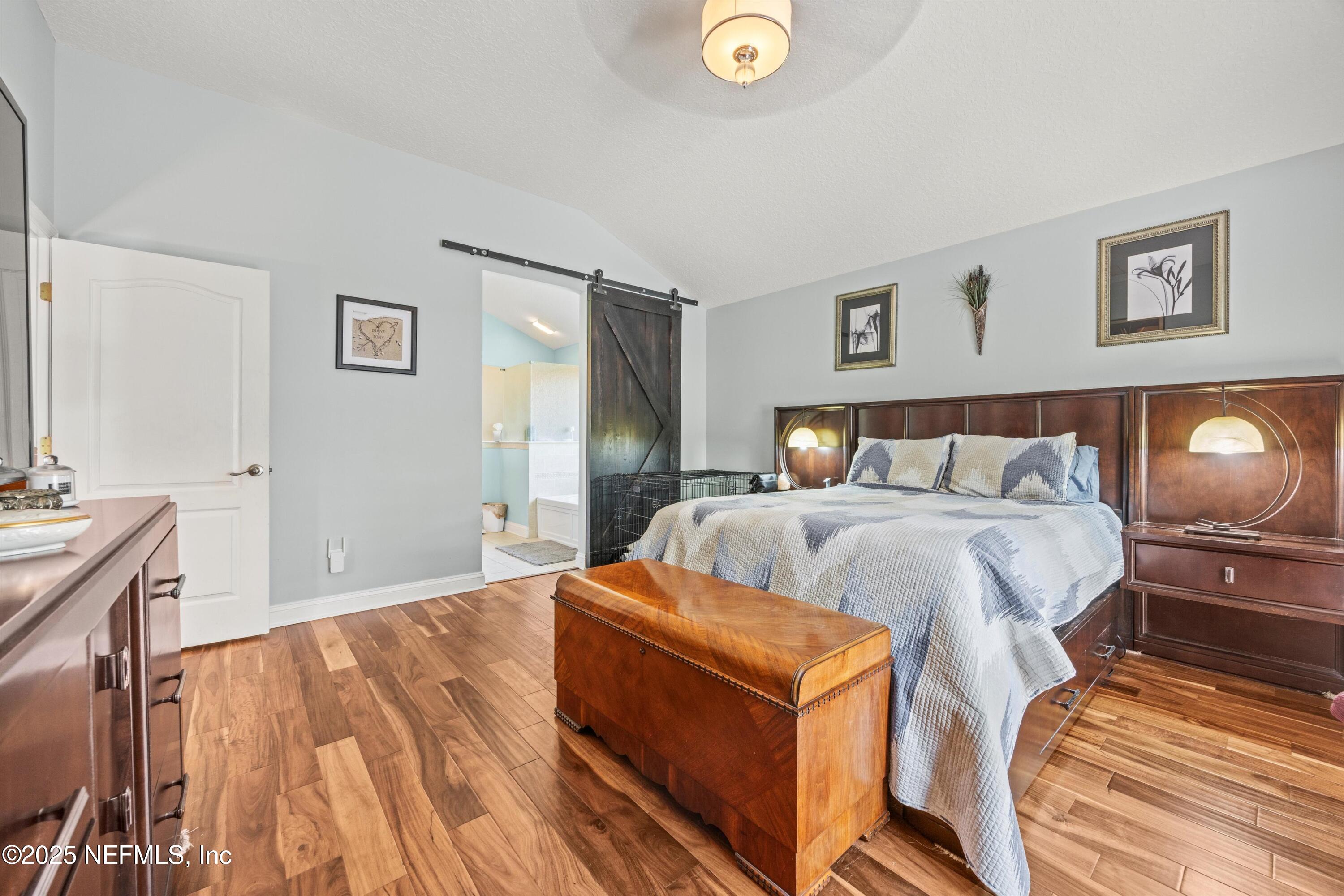 648 Battersea Drive St. Augustine, FL 32095 - Photo 25 of 59 a bedroom with a bed and wooden floor