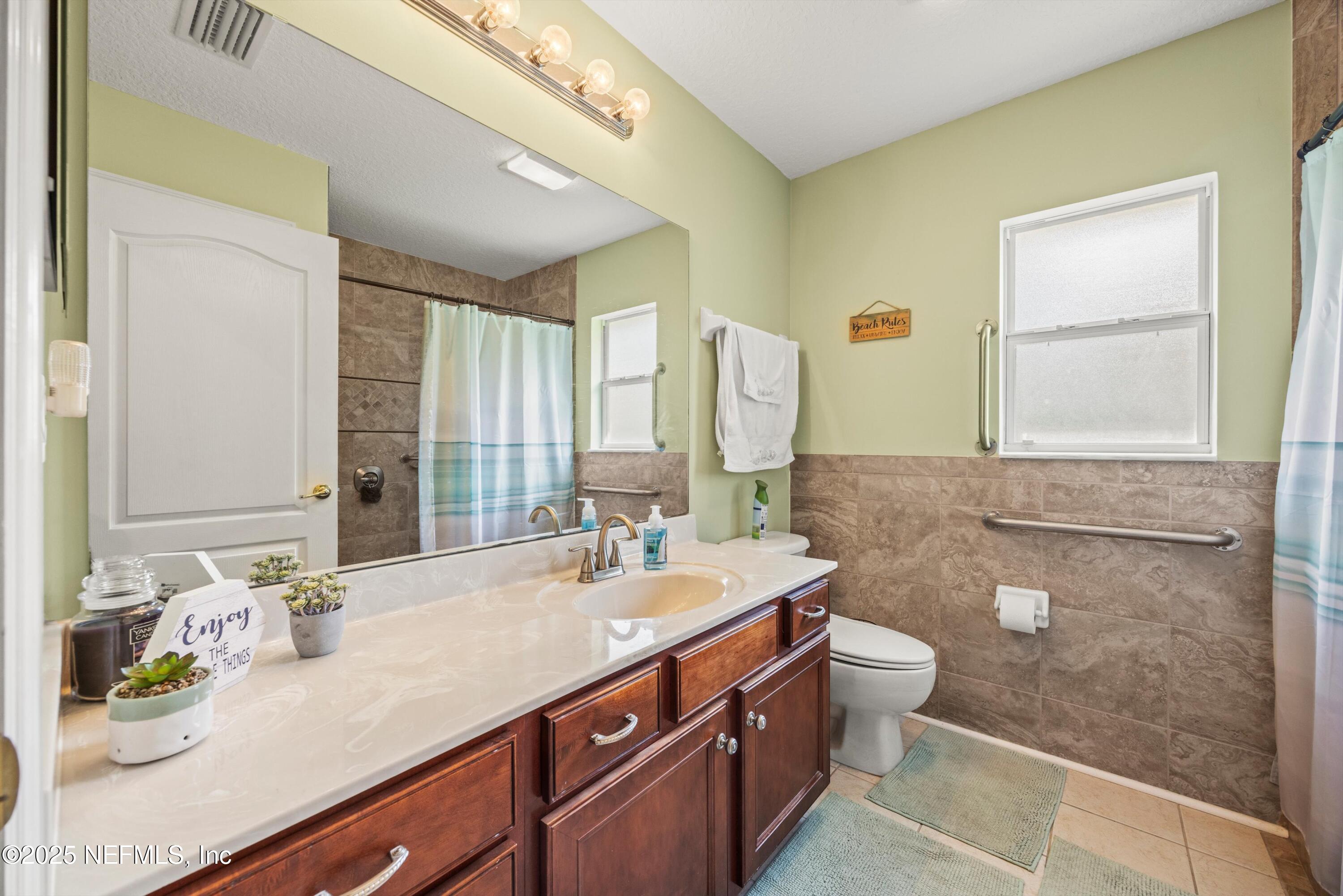648 Battersea Drive St. Augustine, FL 32095 - Photo 30 of 59 a bathroom with a double vanity sink toilet and a mirror