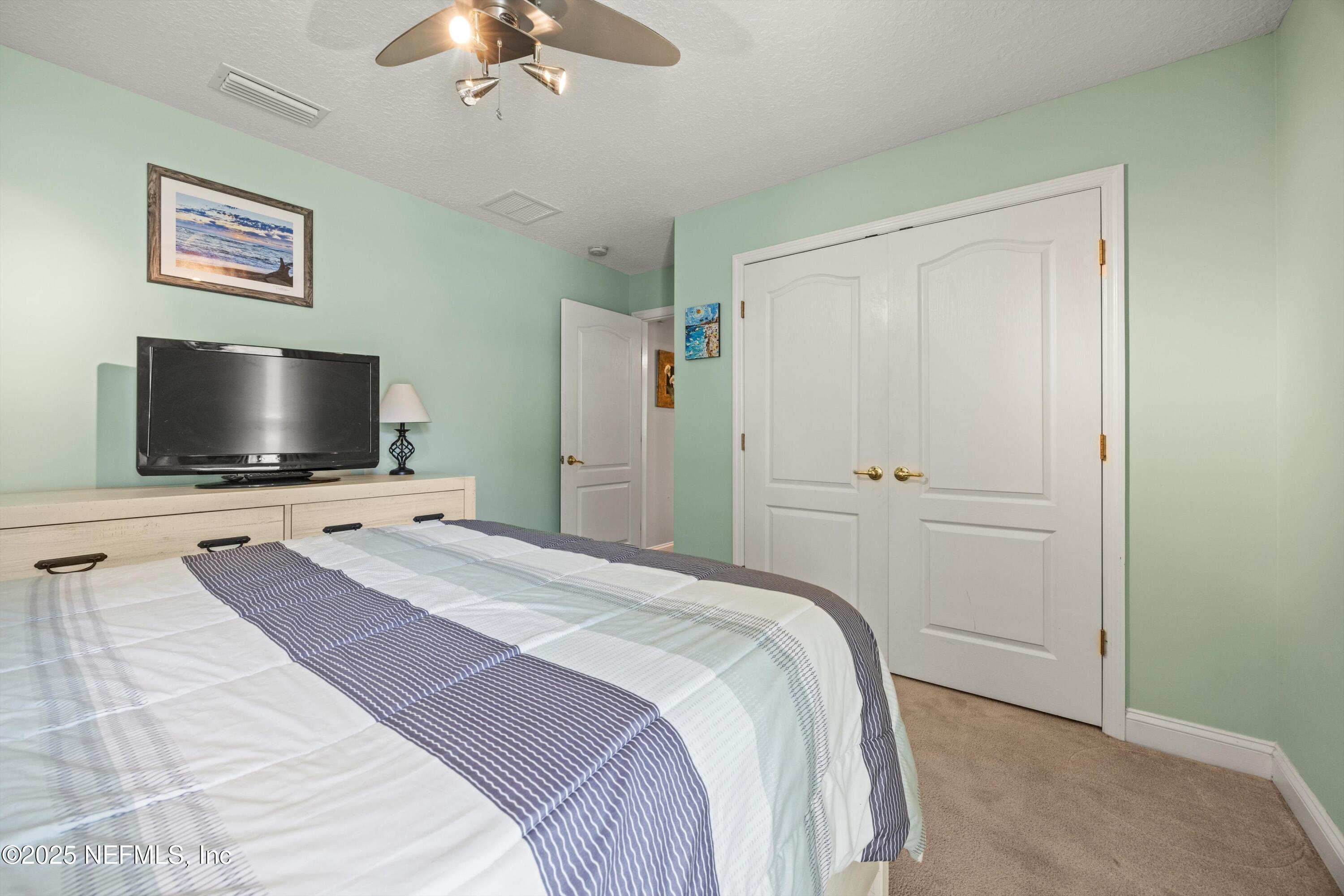 648 Battersea Drive St. Augustine, FL 32095 - Photo 32 of 59 a bedroom with a bed and a flat screen tv