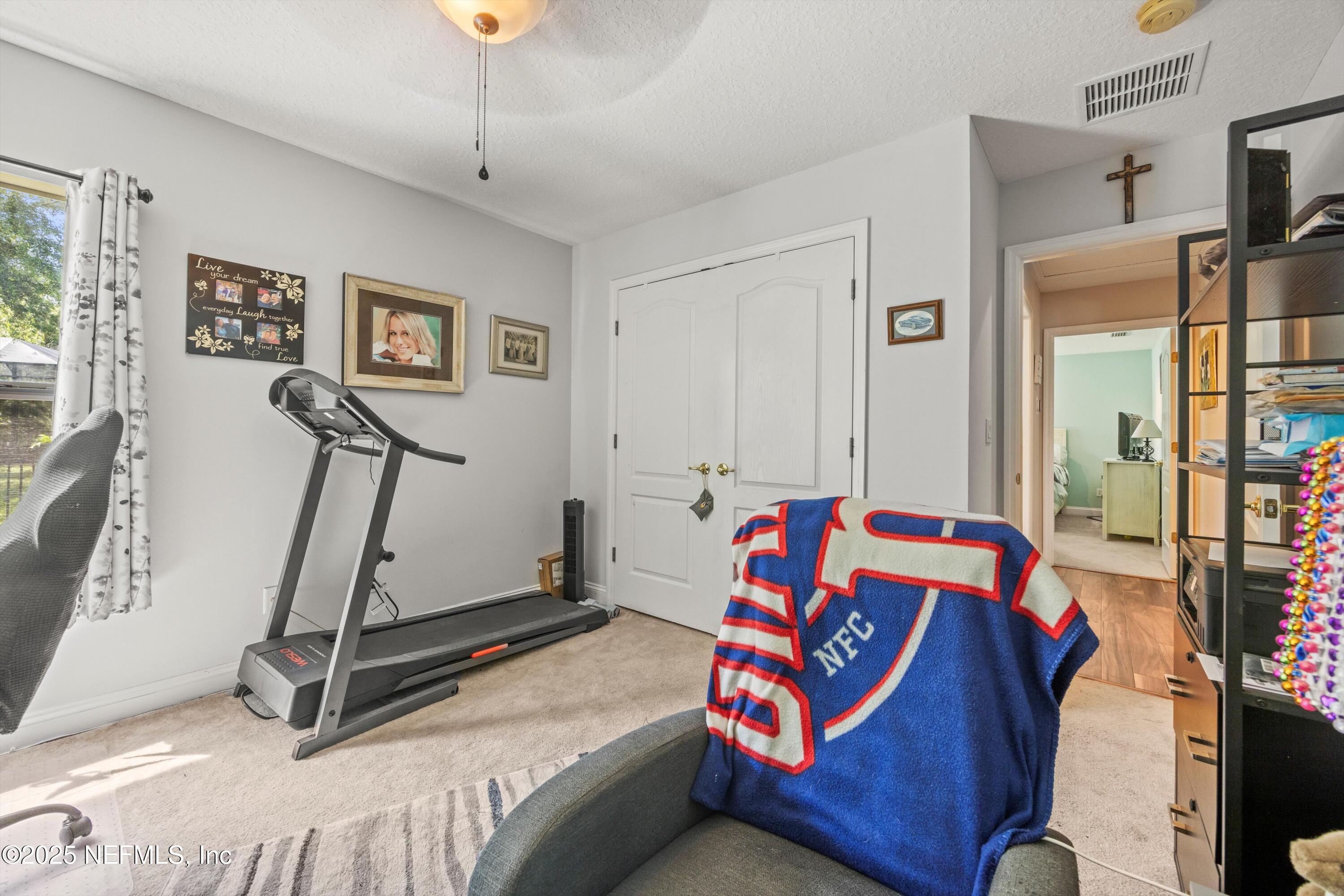 648 Battersea Drive St. Augustine, FL 32095 - Photo 36 of 59 a bedroom with a bed and a chandelier