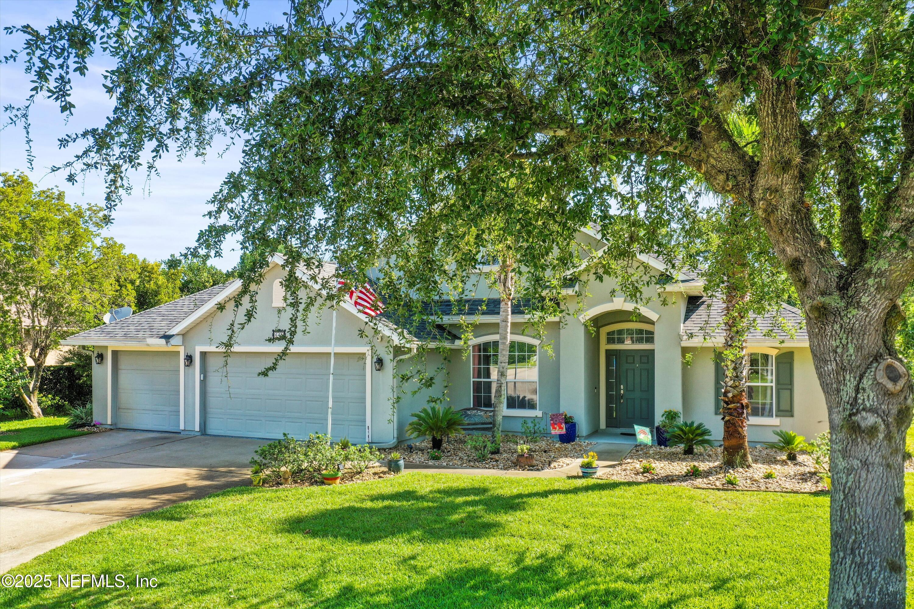 648 Battersea Drive St. Augustine, FL 32095 - Photo 3 of 59 a front view of a house with a yard and trees