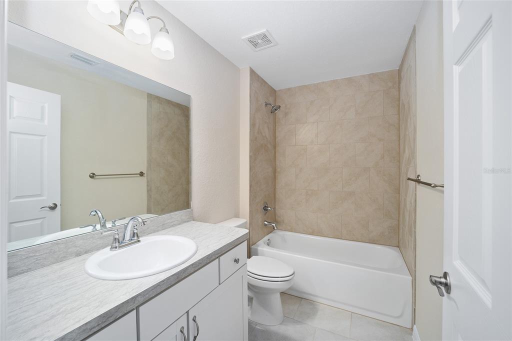 14162 Southwest 16th Place Dunnellon, FL 34432 - Photo 10 of 15 a bathroom with a granite countertop sink toilet a mirror and shower