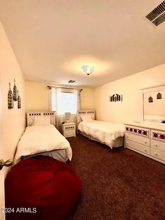 a large bed sitting in a bedroom next to a larger window