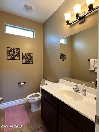 a bathroom with a granite countertop sink a mirror and a toilet