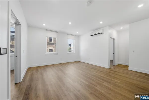 a view of empty room with wooden floor