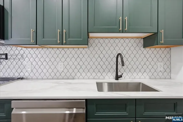 a kitchen with stainless steel appliances granite countertop a sink and a refrigerator