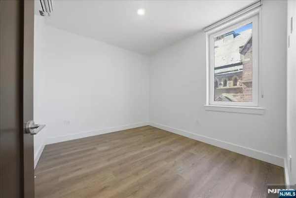 a view of kitchen with stainless steel appliances kitchen island refrigerator stove and wooden floor
