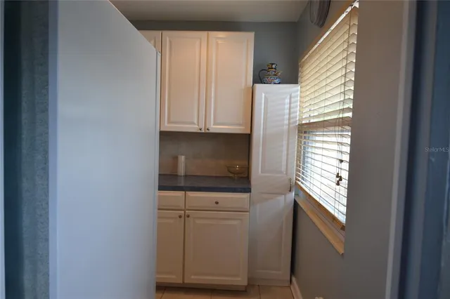 a kitchen with granite countertop white cabinets and stainless steel appliances