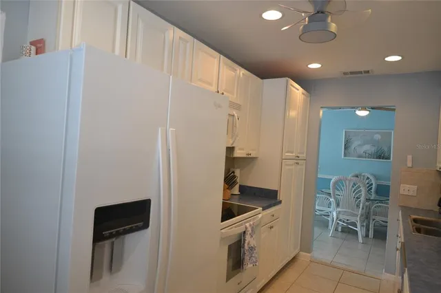 a kitchen with stainless steel appliances a sink a stove a refrigerator cabinets and a counter top space