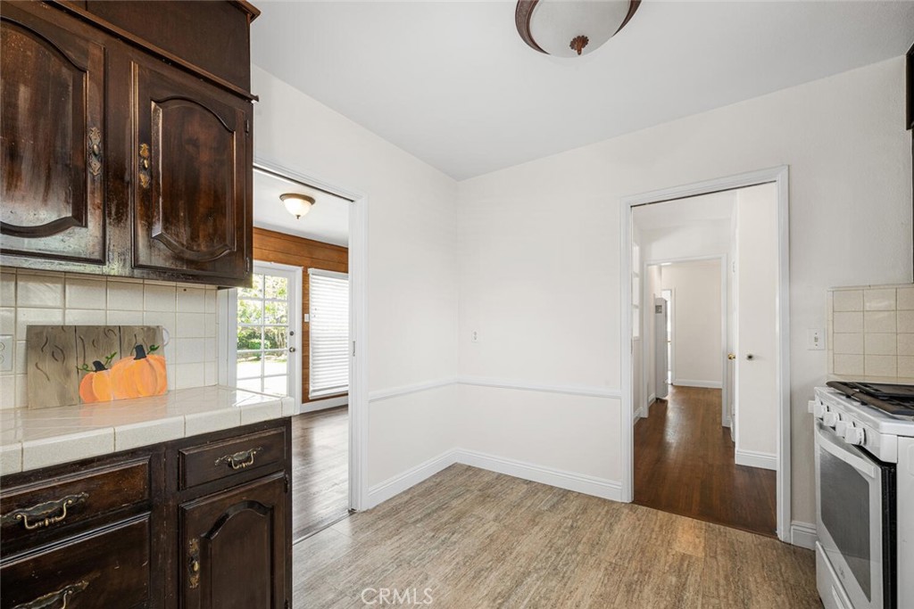 2154 North Studebaker Road Long Beach, CA 90815 - Photo 12 of 37 a kitchen with granite countertop a stove a refrigerator and a sink with wooden floor