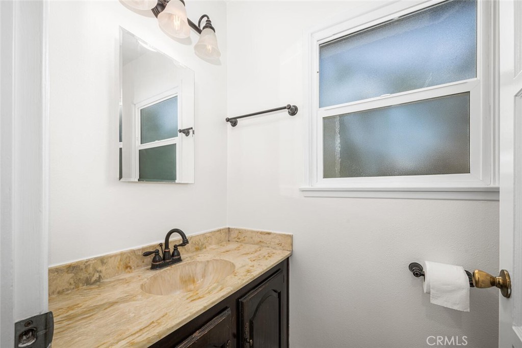 2154 North Studebaker Road Long Beach, CA 90815 - Photo 14 of 37 a bathroom with a granite countertop sink and a mirror