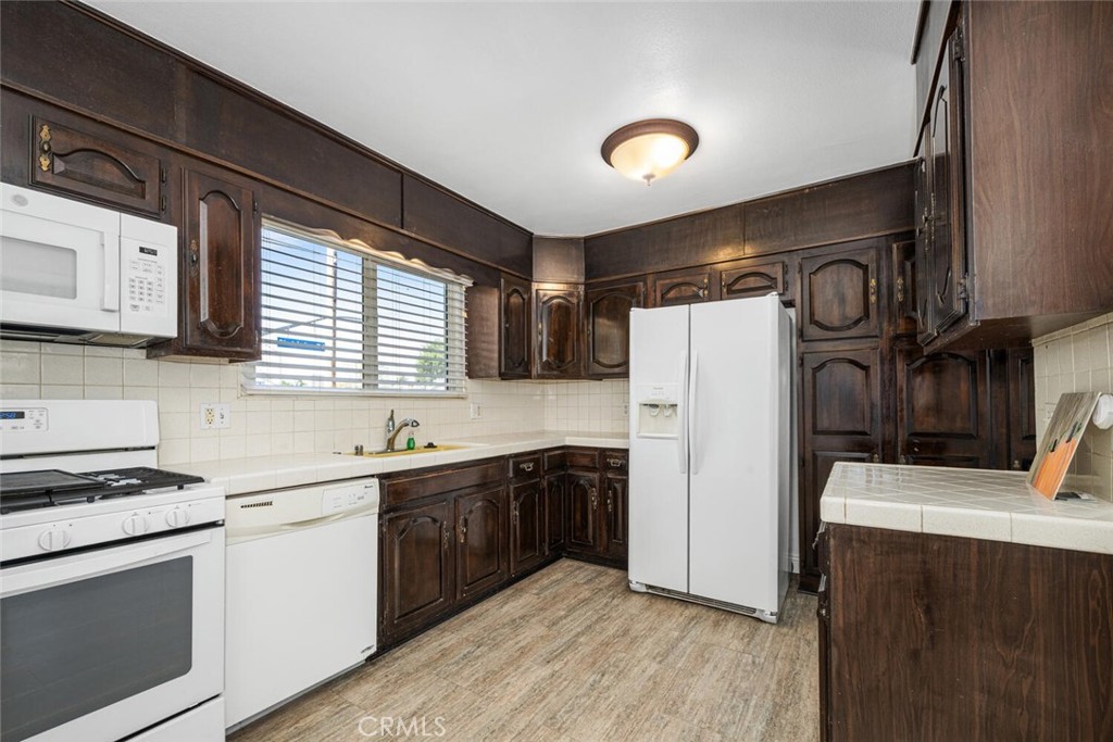 2154 North Studebaker Road Long Beach, CA 90815 - Photo 10 of 37 a kitchen with a refrigerator sink and white cabinets