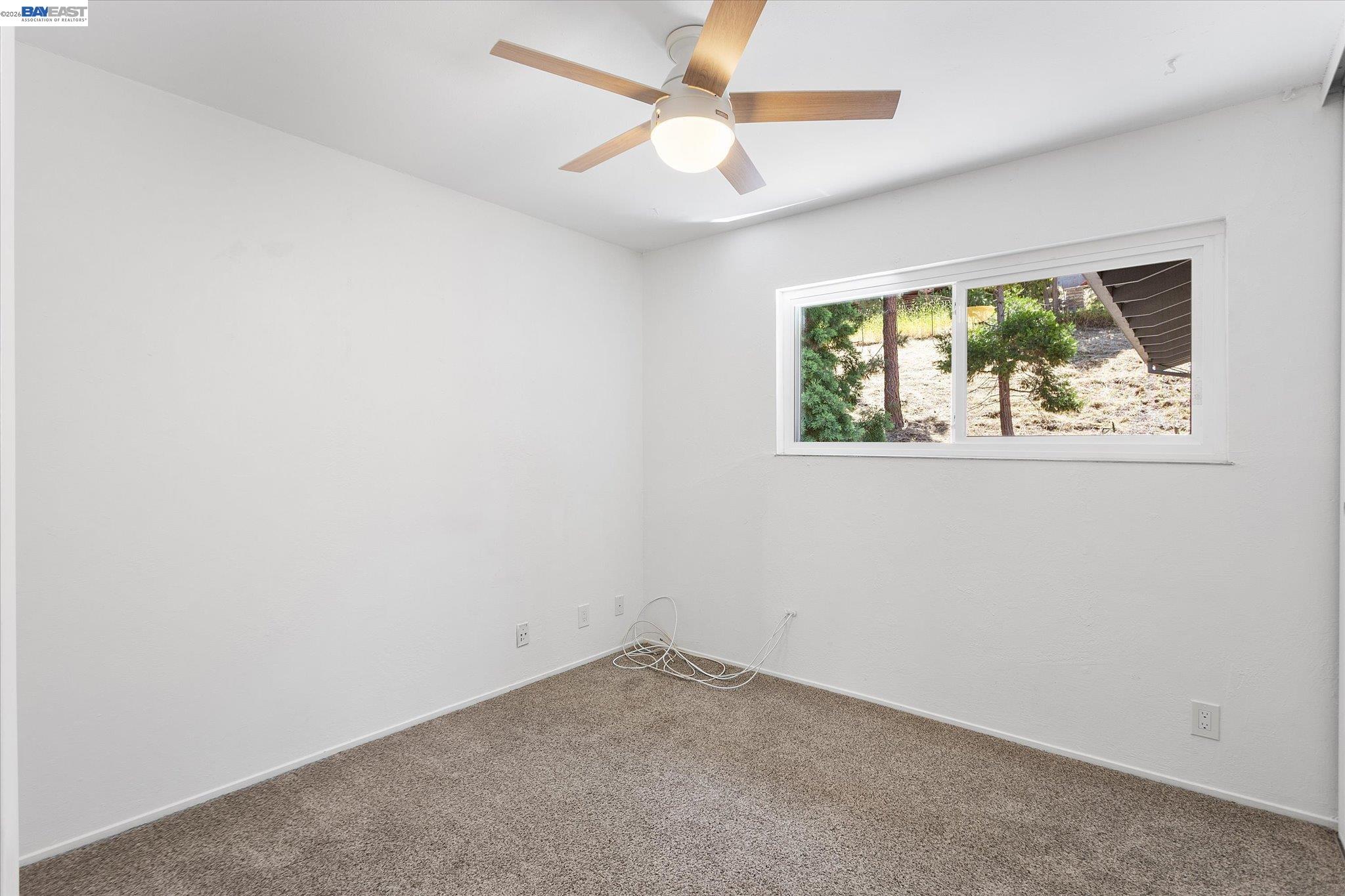 16683 Kildare Road Castro Valley, CA 94546 - Photo 45 of 77 an empty room with a window and a fan