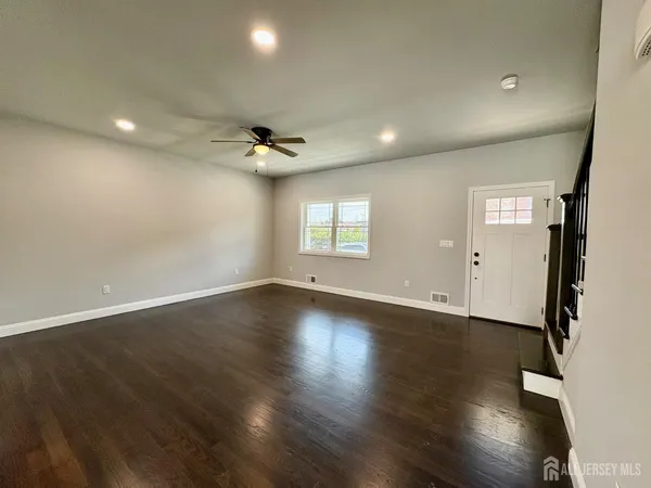 an empty room with wooden floor and window