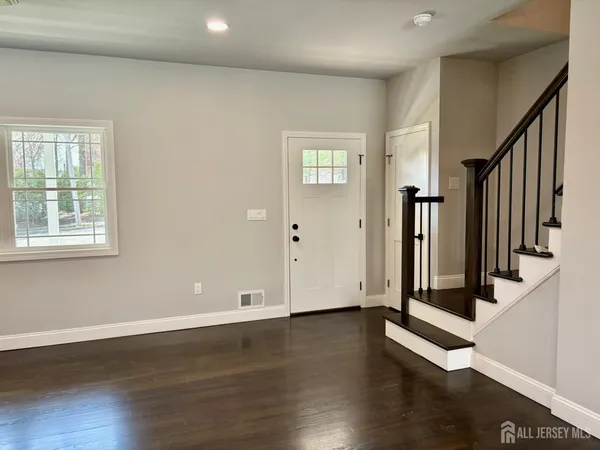 a view of a hallway with wooden floor and windows