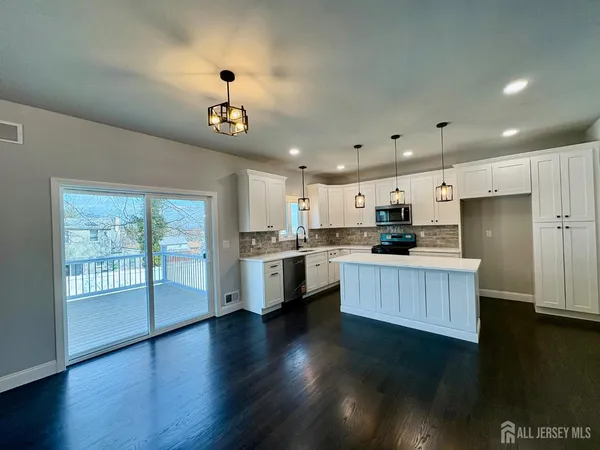 an empty room with wooden floor ceiling fan and windows